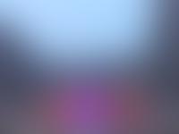 Stage in the stadium with the artist on stage. The stadium has an open roof and an airplane is rising right behind the stadium. The day is moving to night, and the stage LED screens are the brightest part of the stadium.